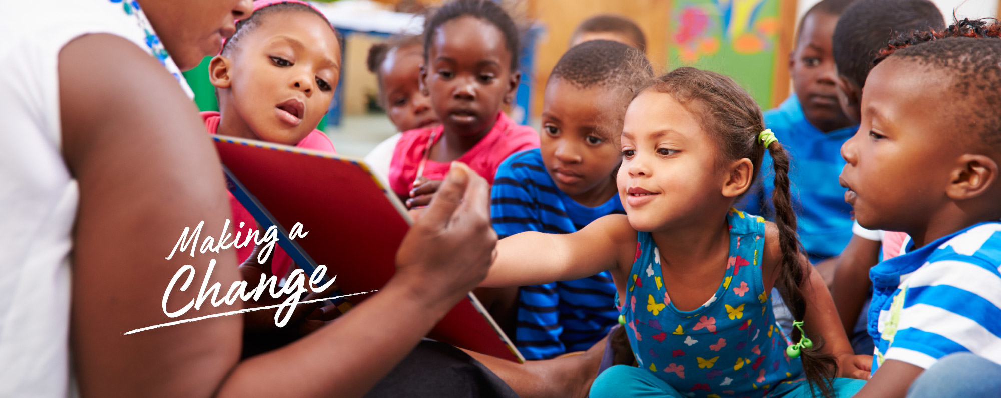 children gathered around their teacher reading a book